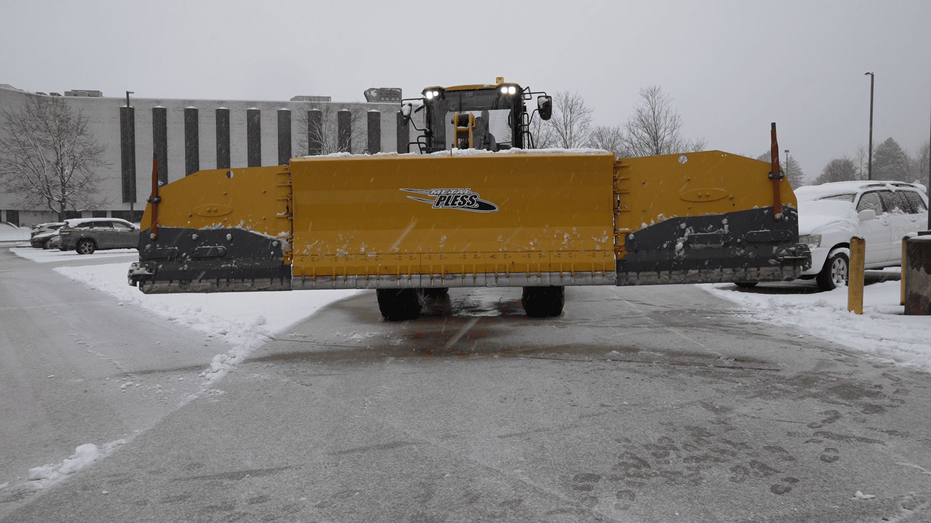 A snow plow is parked in the middle of a road.