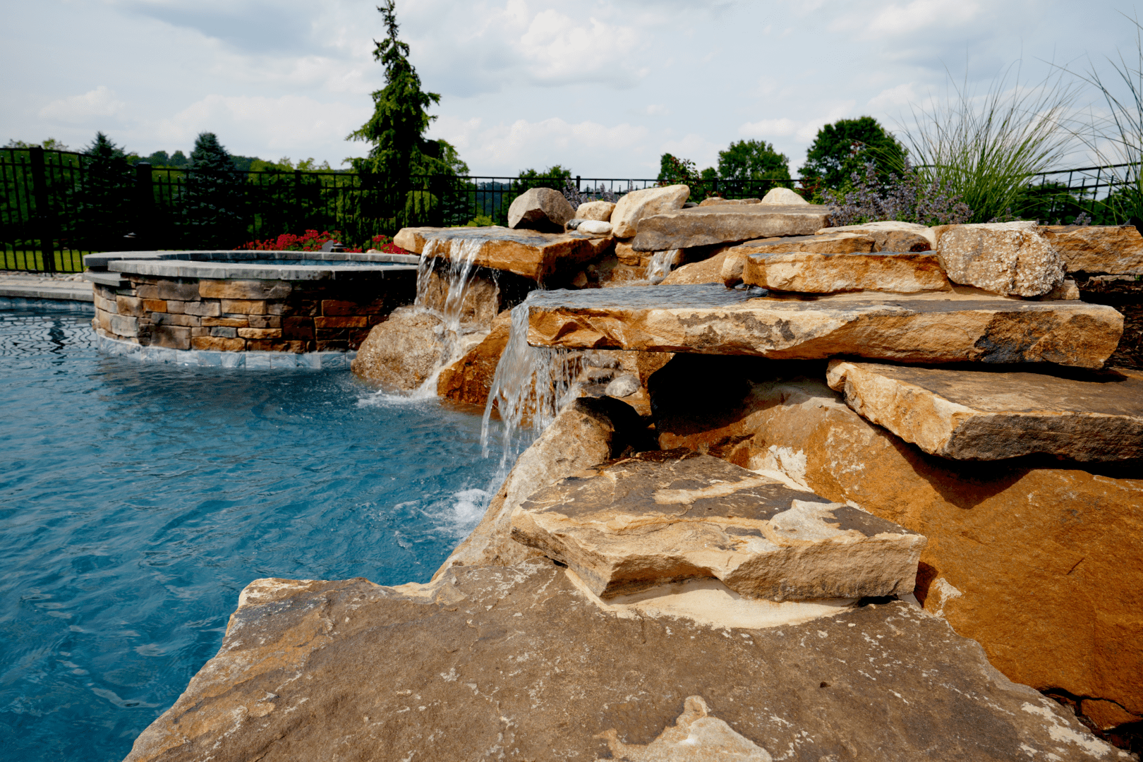 A pool with a mesmerizing waterfall, showcasing stunning water features.