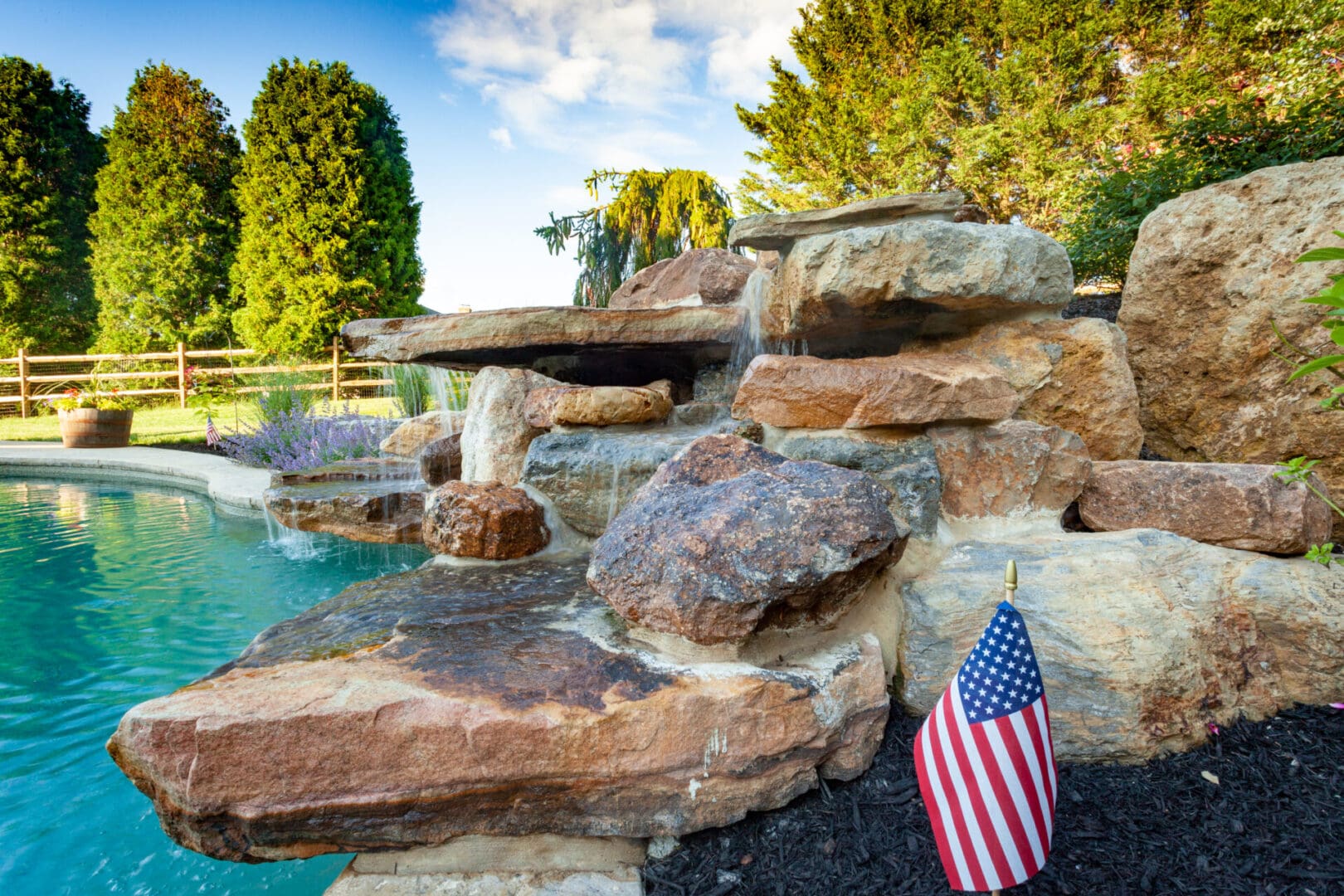 A pool with water features including a waterfall and a flag.