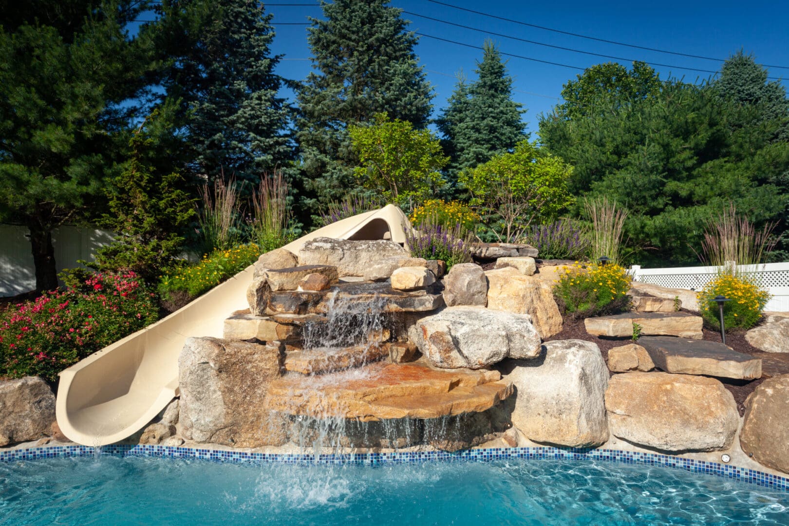 A pool with water features such as a slide and a waterfall.