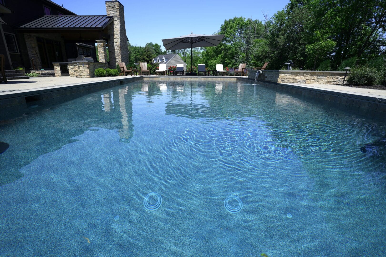 A meticulously crafted swimming pool in a picturesque backyard showcasing exquisite pool design.
