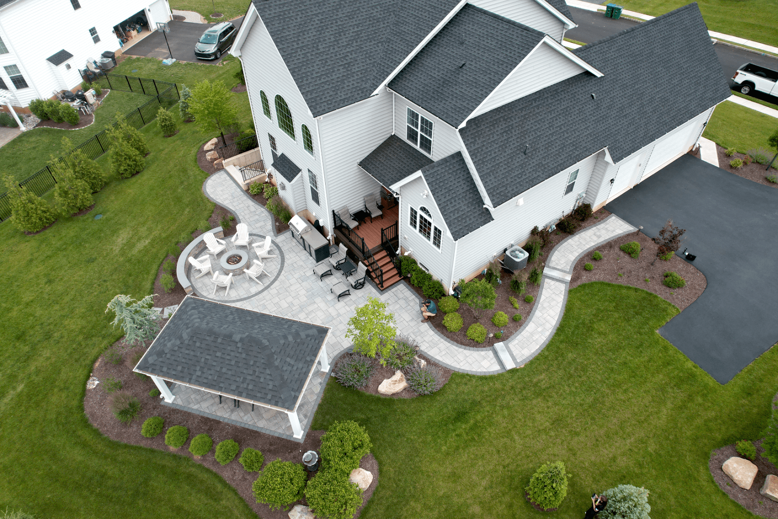 An aerial view of a home with a large backyard showcasing stunning landscape design.