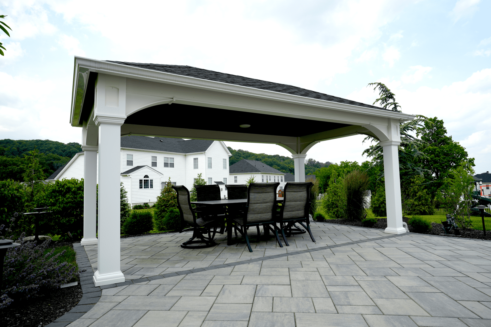 A custom gazebo with a table and chairs on a patio.
