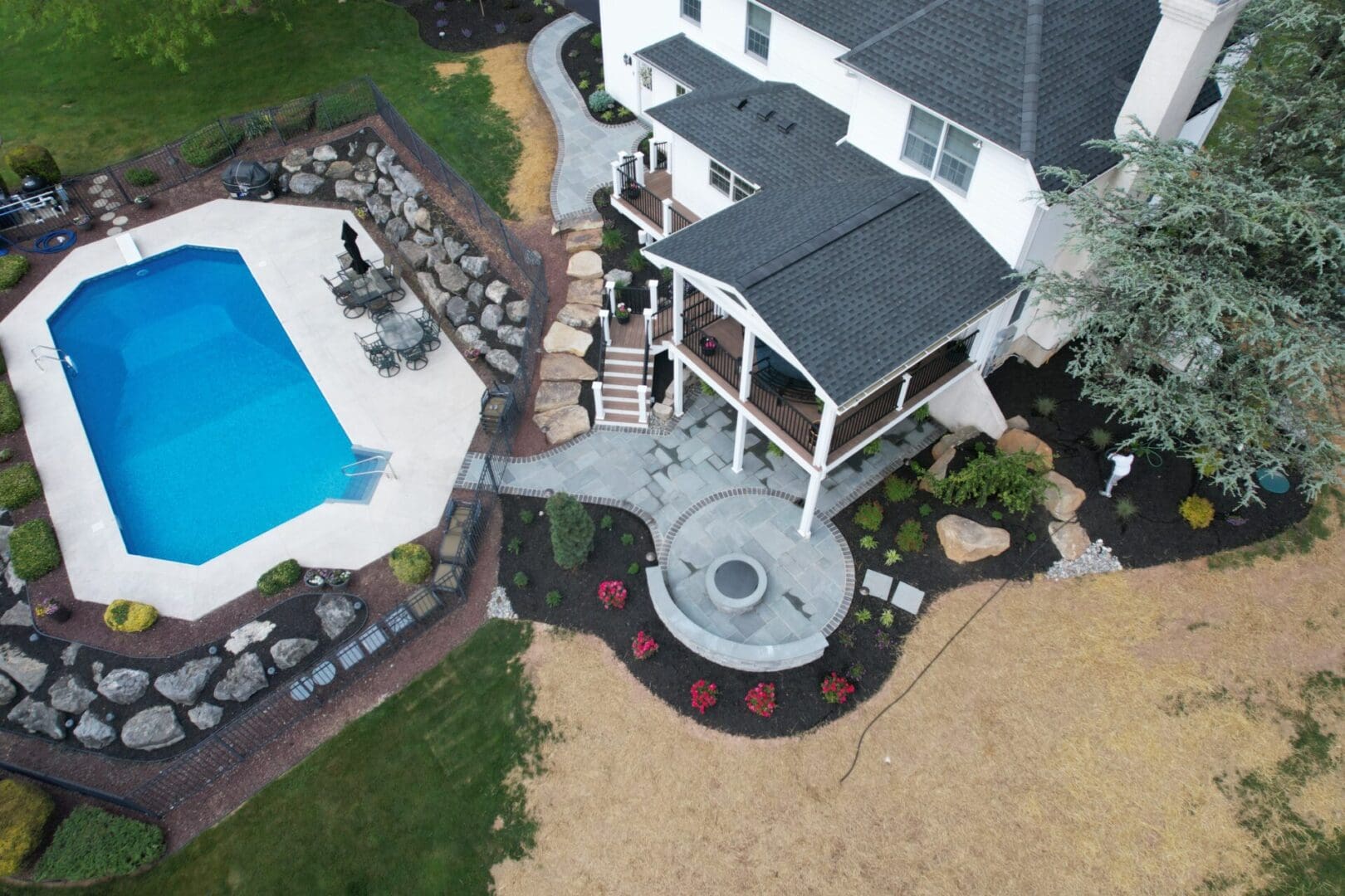 An aerial view of a house with a pool surrounded by lush landscaping designed by Planting Professionals.