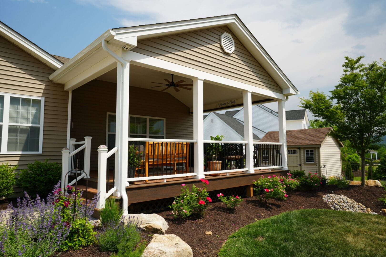 A custom home with a porch and landscaping.