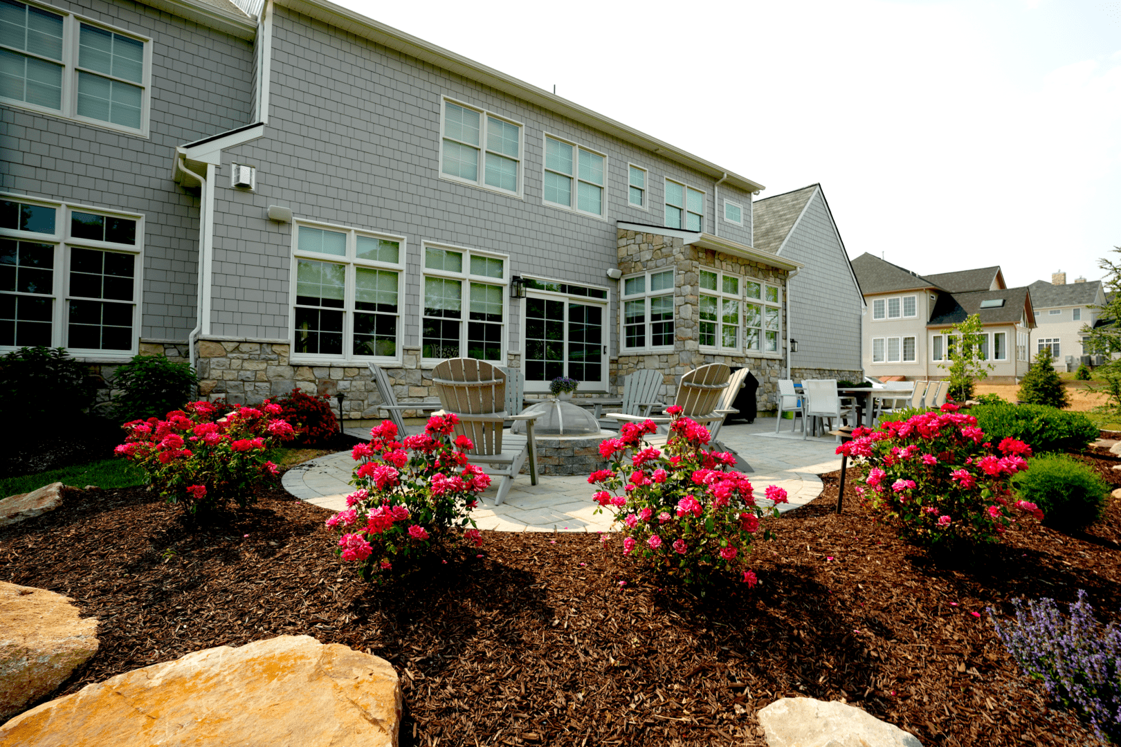 A gray house adorned with flowers by Planting Professionals.