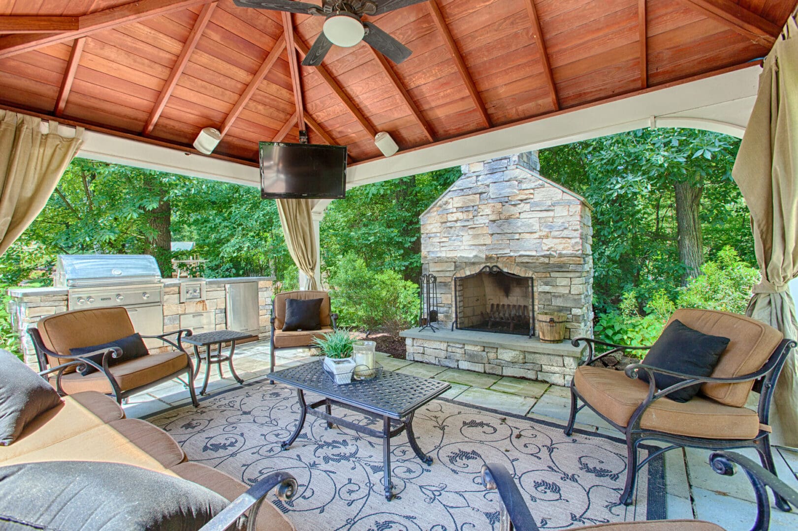 A custom structure: a screened-in porch with a fireplace and patio furniture.