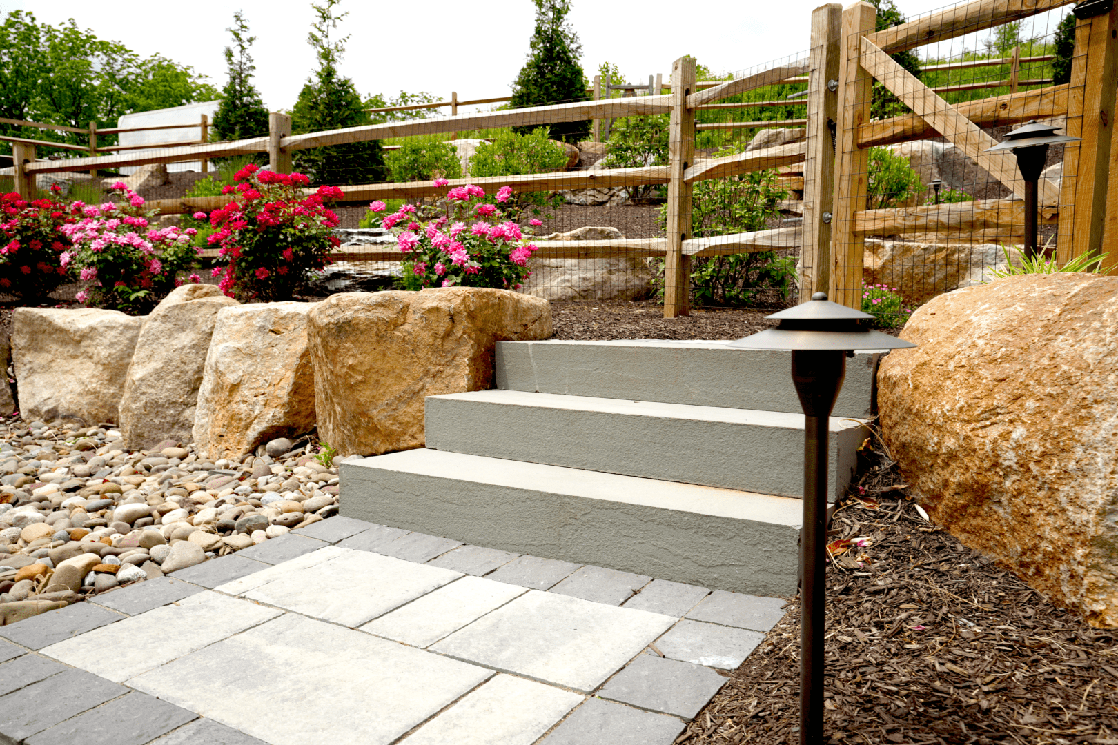 A hardscape design featuring a stone path leading to a serene rock garden.