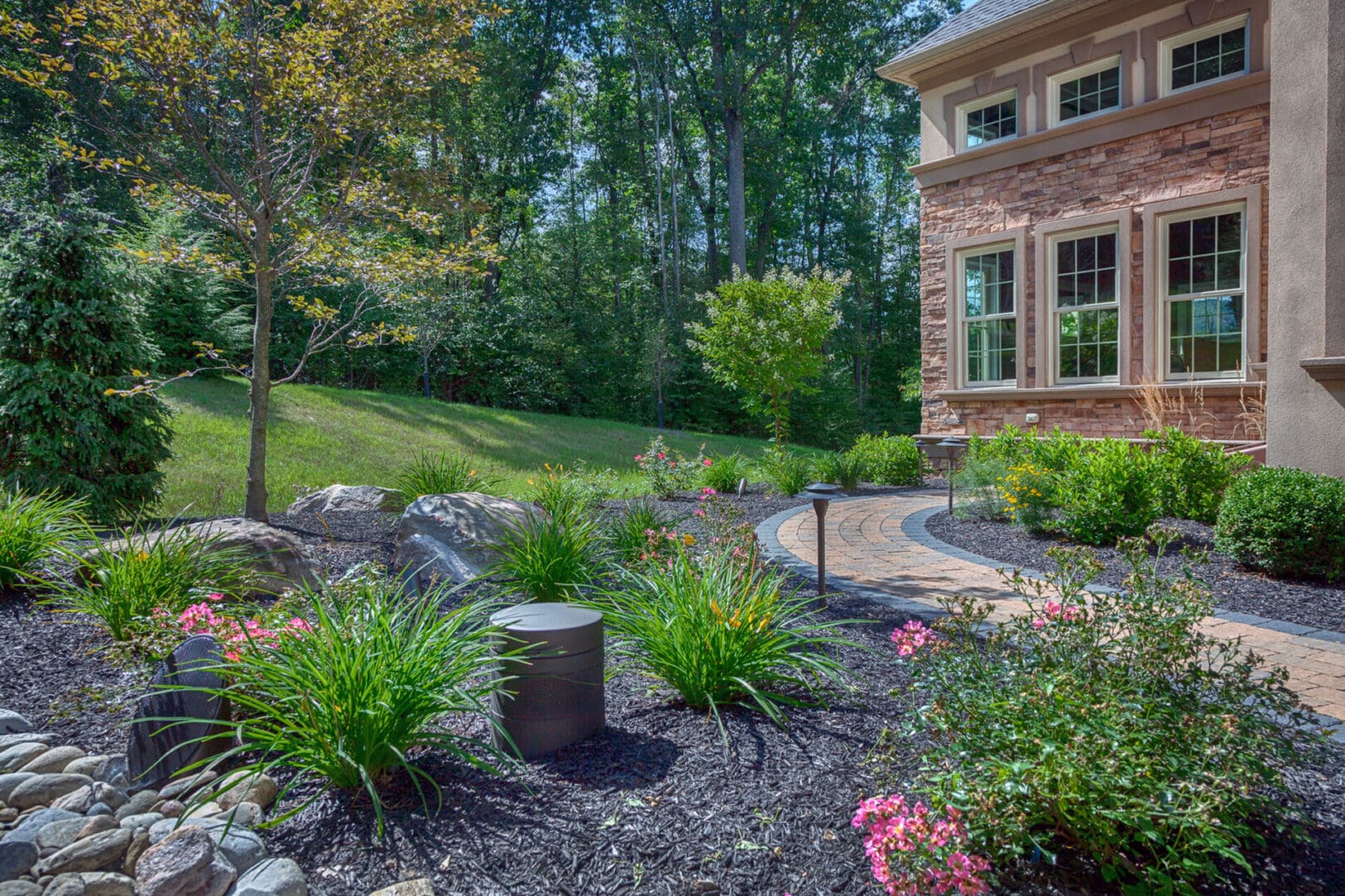 A home with a stone walkway, outdoor lighting, and landscaping.