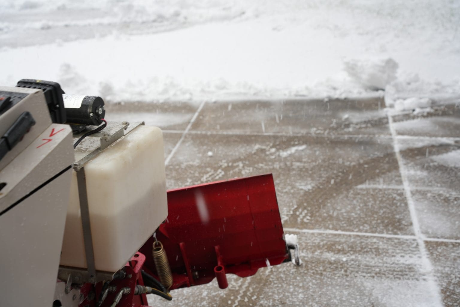 A commercial snow blower is being used for efficient snow and ice management on a sidewalk.
