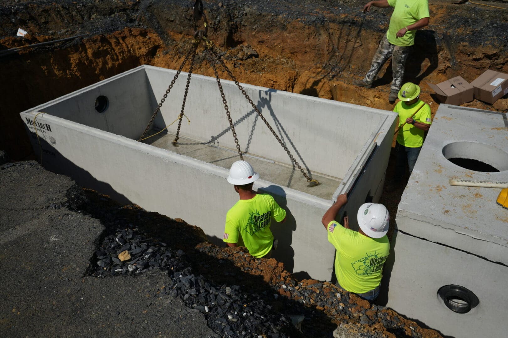 A group of construction workers engaged in site work on a concrete slab.