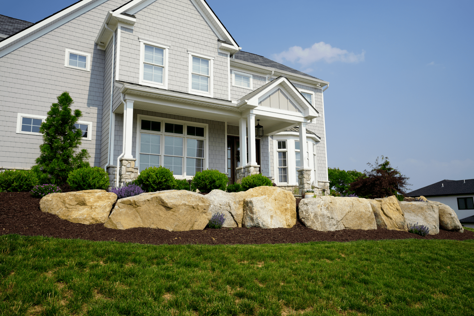 A boulder in front of a house.