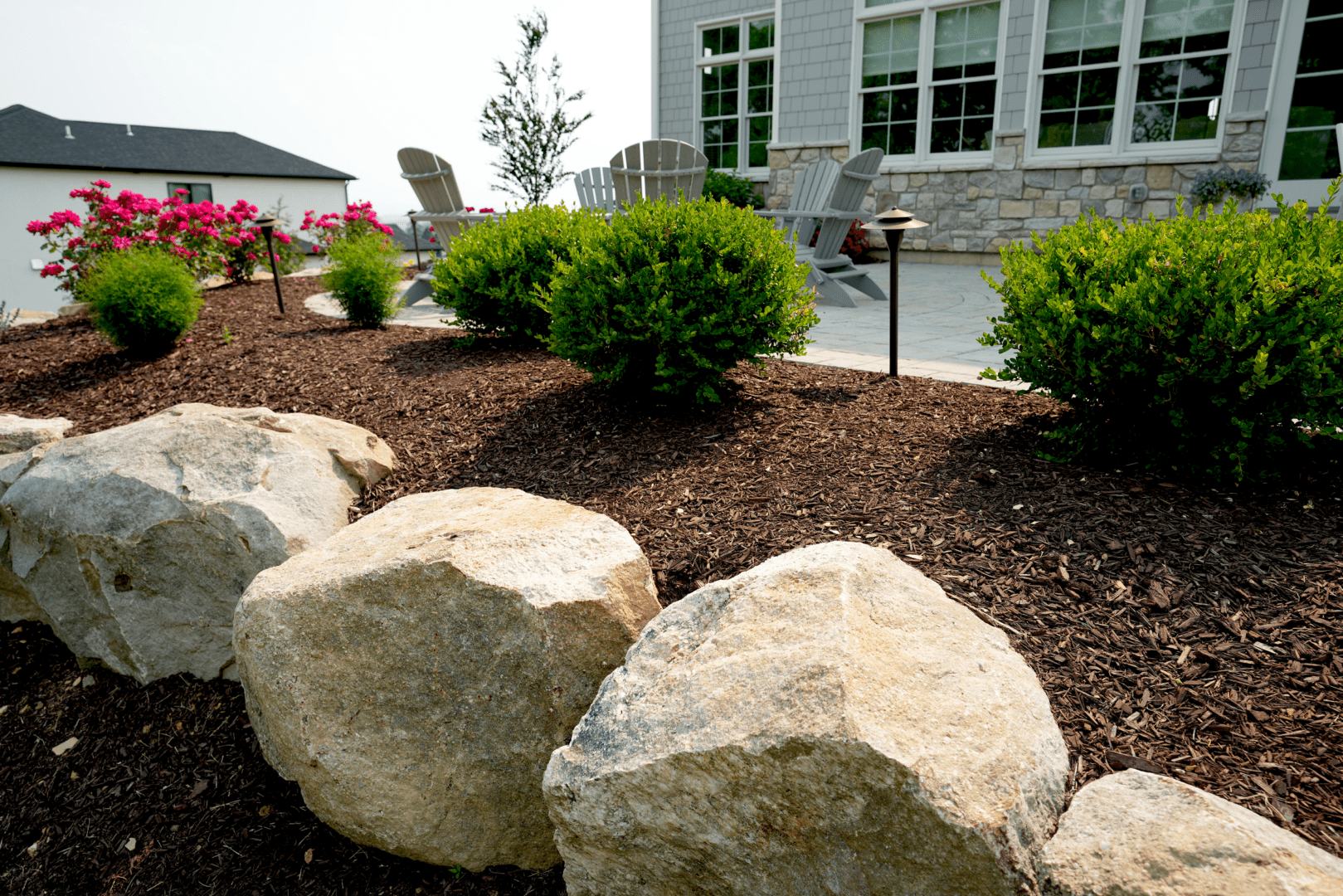 A boulder garden in front of a house.