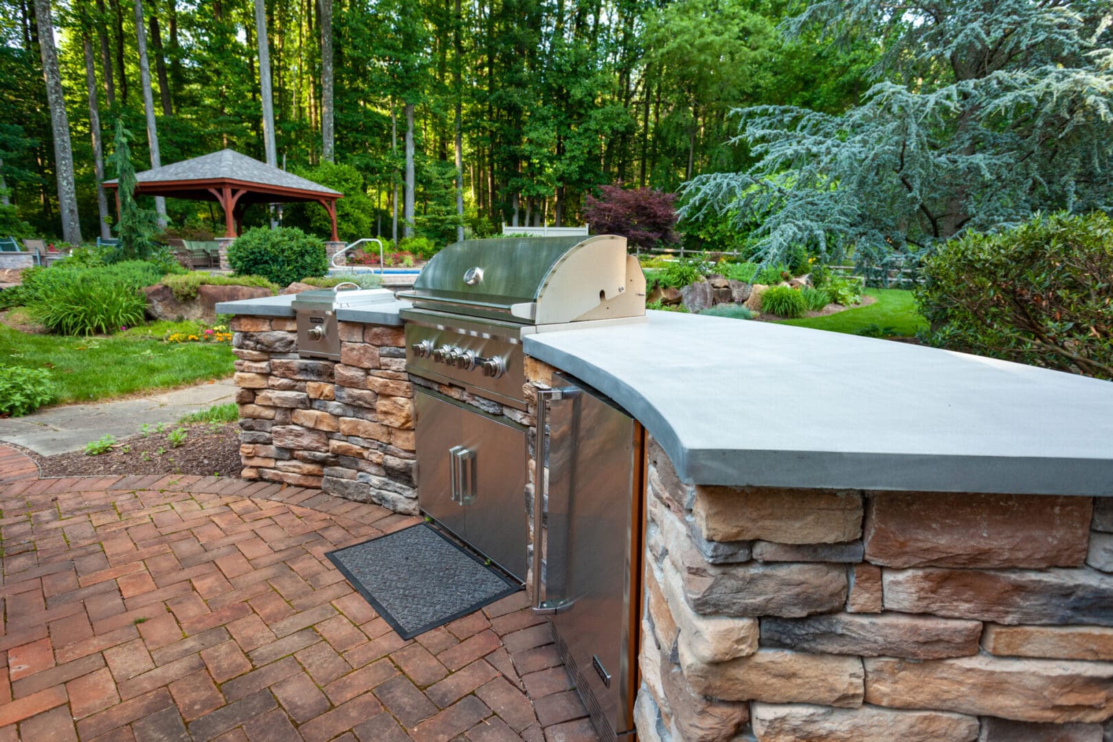 A custom outdoor kitchen with a grill and a fireplace.