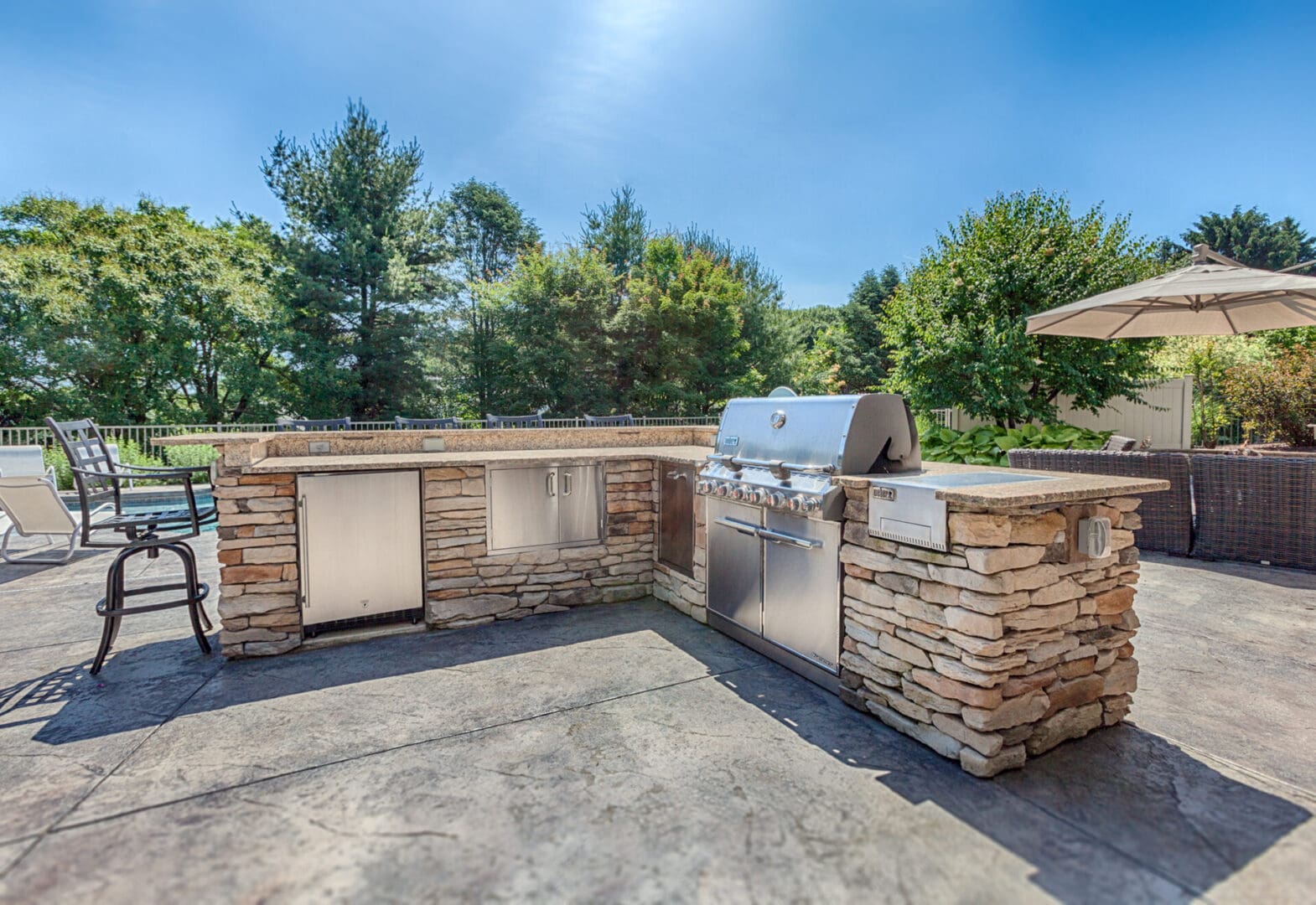 A custom outdoor kitchen with a grill and patio furniture.
