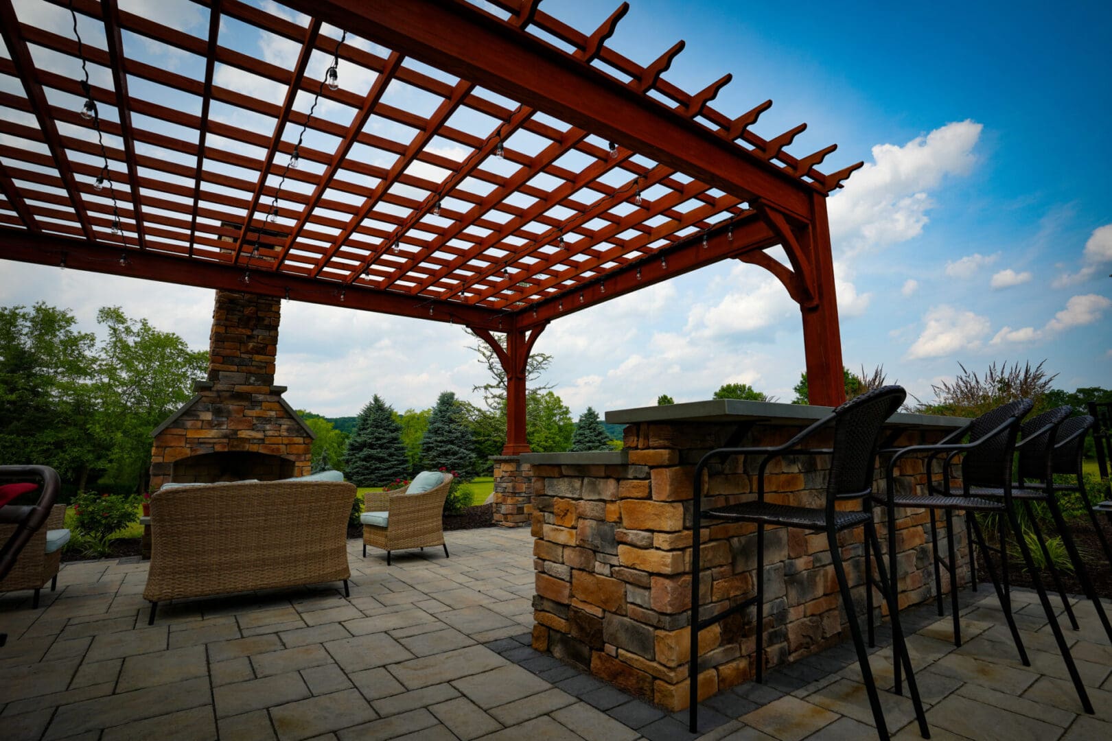 A patio with a fire pit and a pergola.