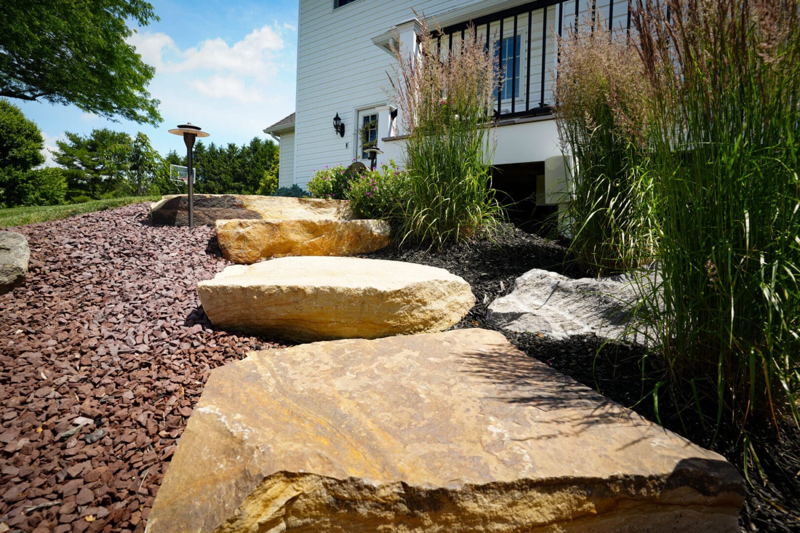 A couple of large rocks in the middle of a garden.