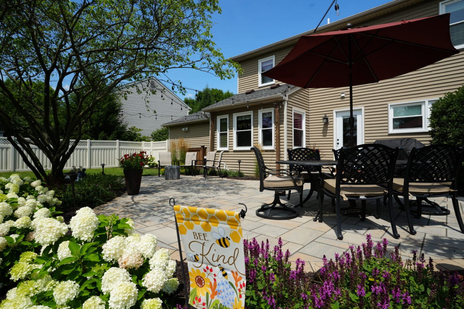 A patio with flowers and a table in the background.