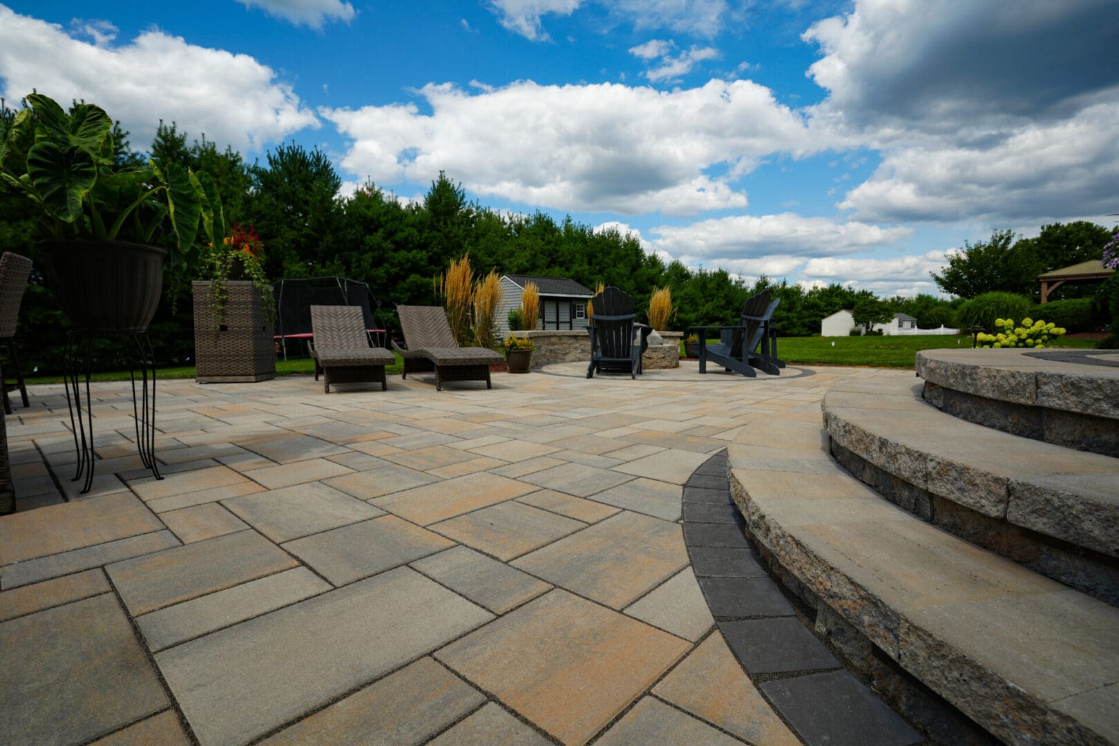 A patio with chairs and steps in the background.