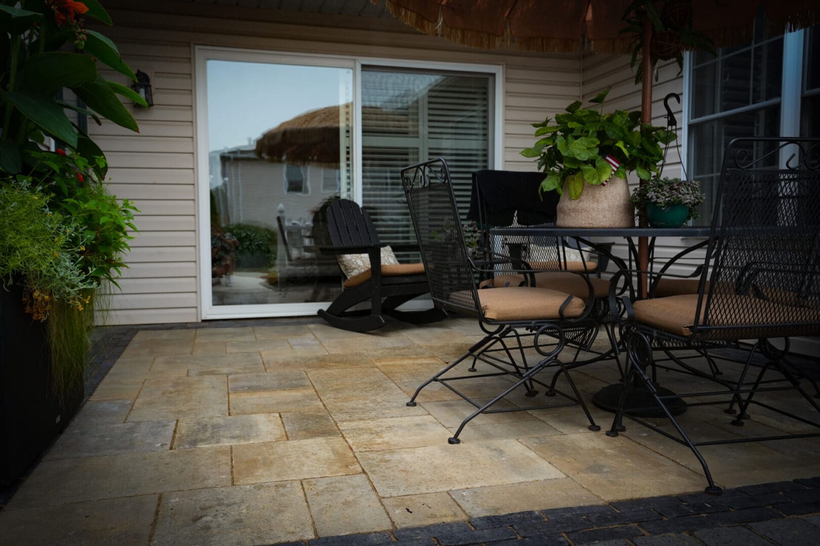 A patio with chairs and tables outside of the house.