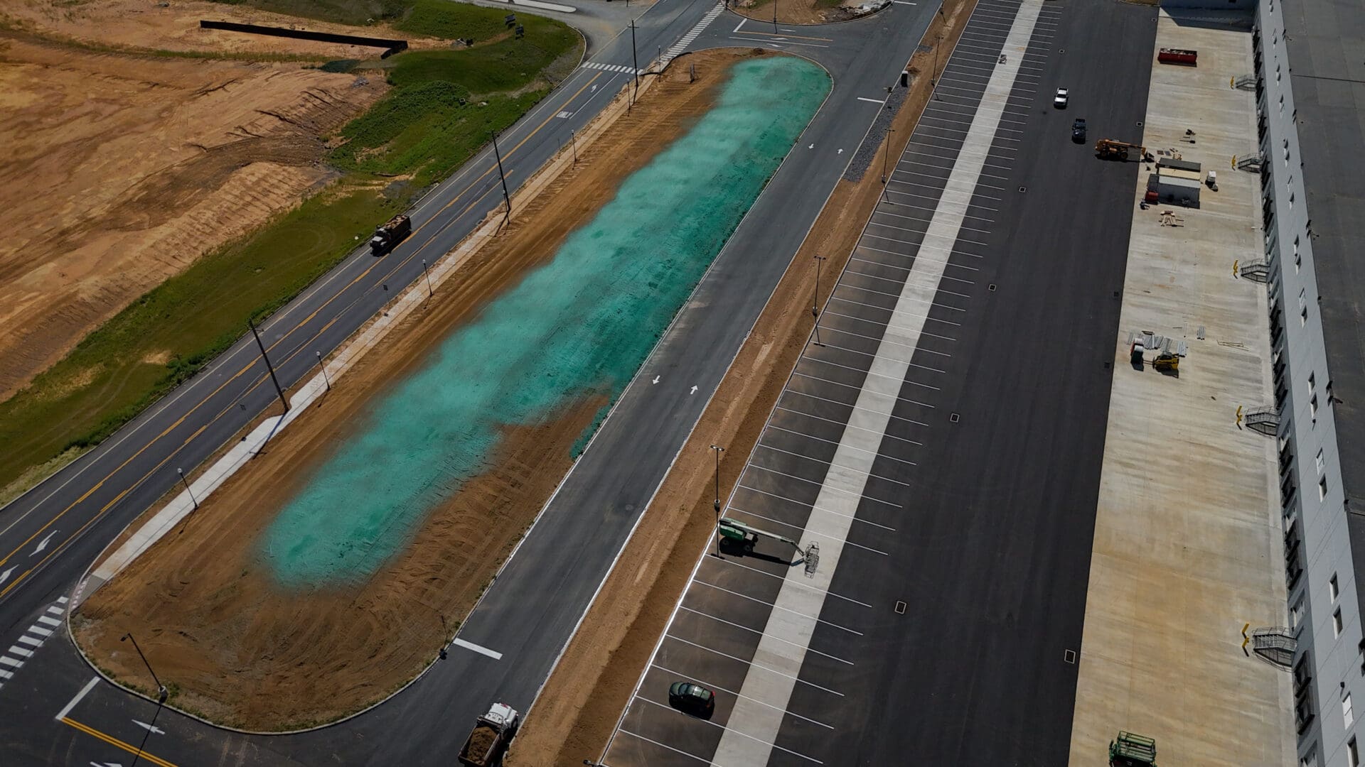 A road with a blue water filled trough on the side of it.