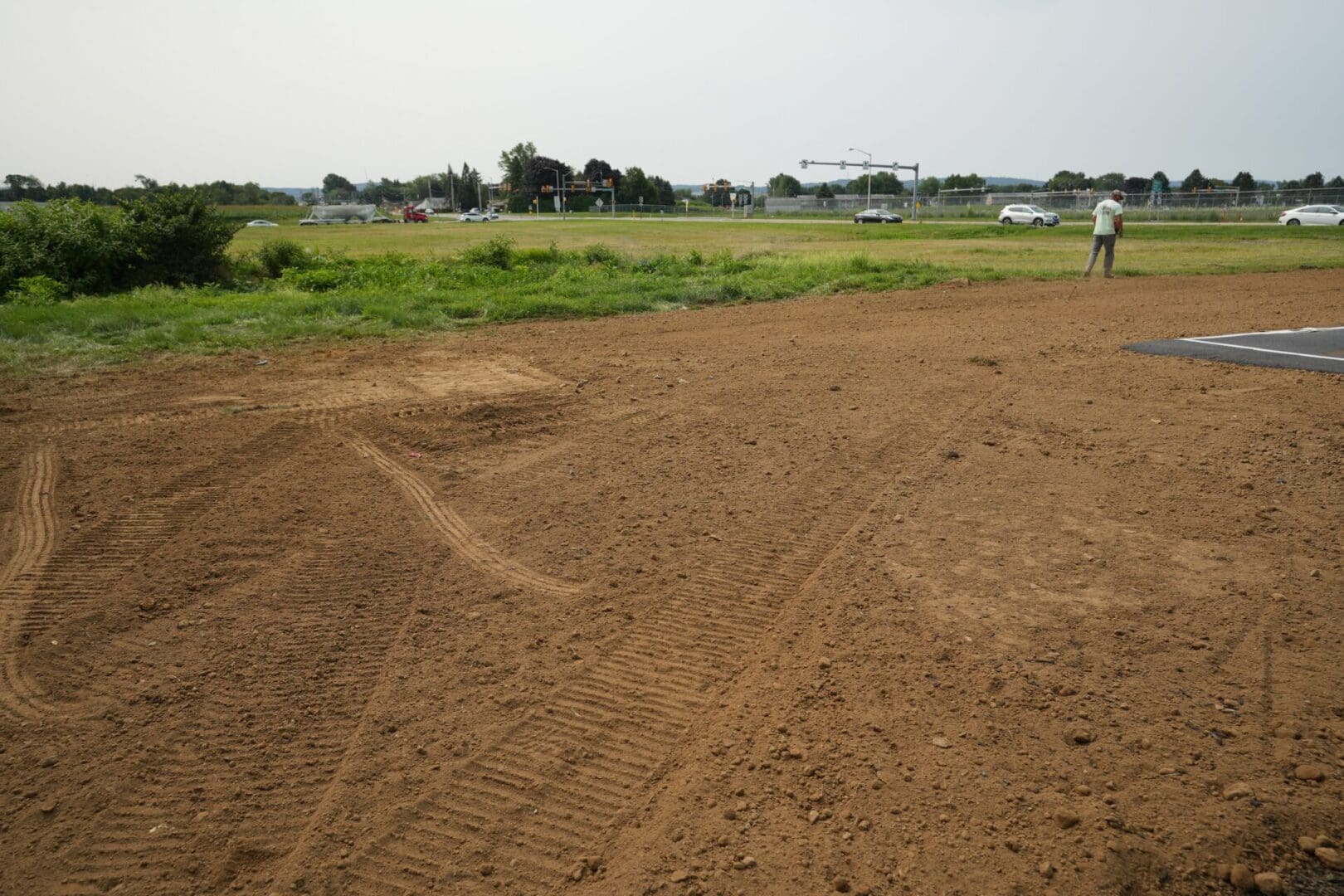 A dirt field with a person walking on it