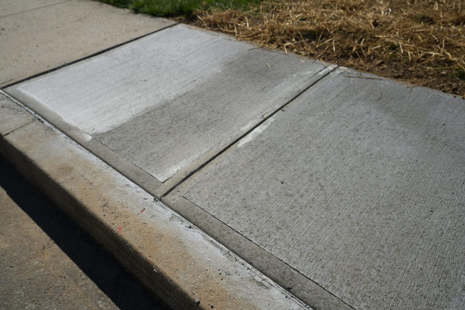 A sidewalk with concrete steps and grass.