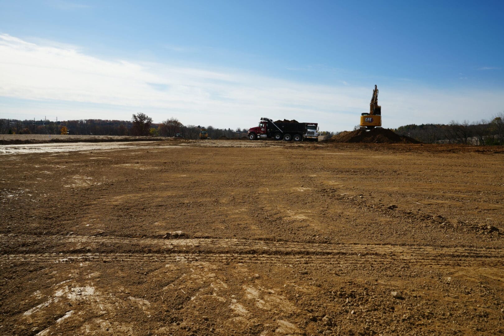 A large field with a tractor in the middle of it.