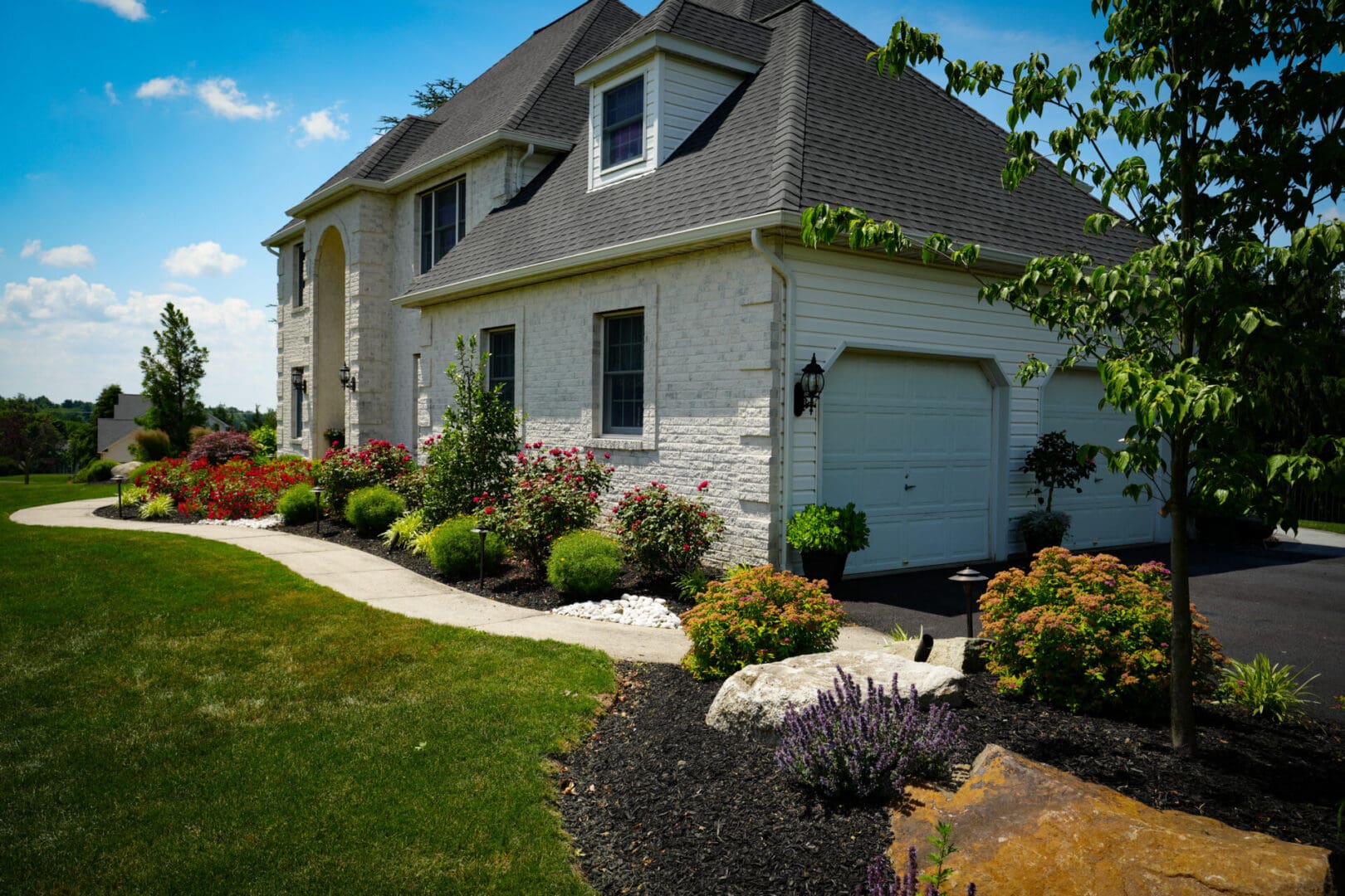 A house with a garden and bushes in front of it