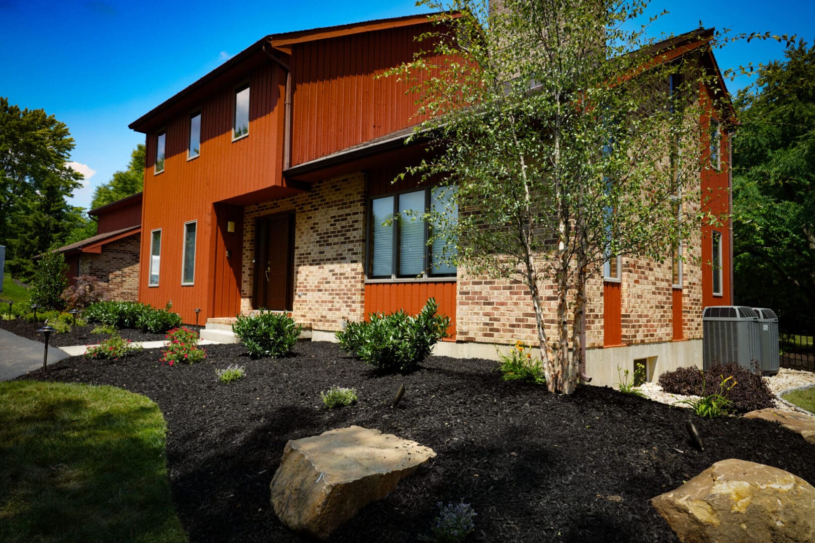 A red house with a tree in the front yard