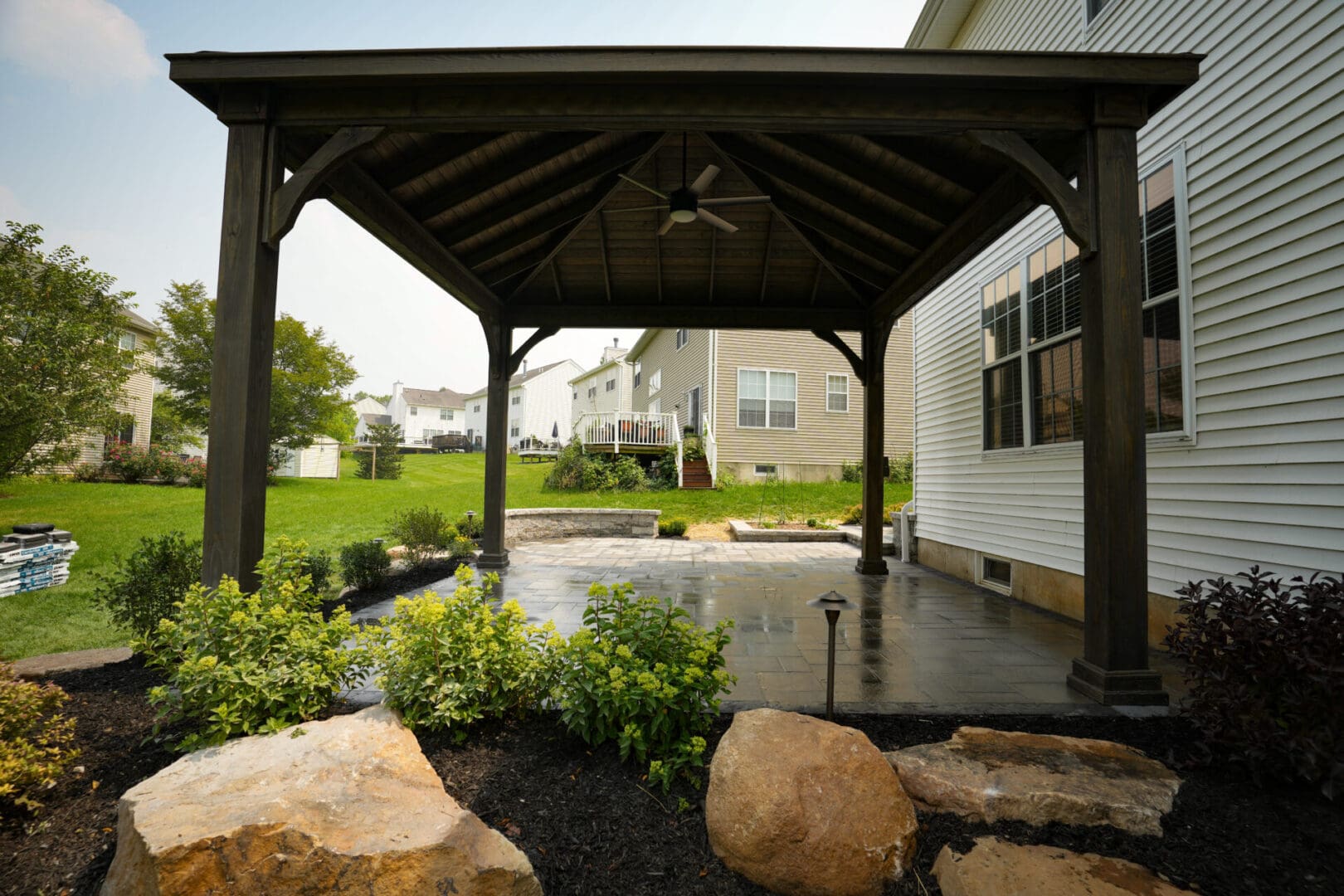 A covered patio with a rock garden and a gazebo.