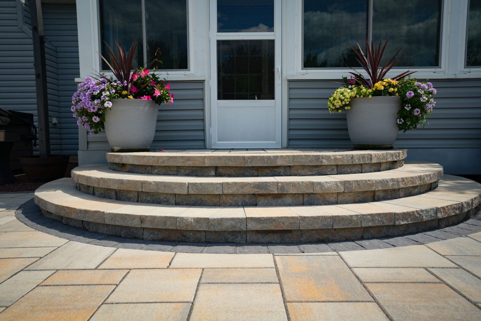 A front porch with steps and flowers on the steps.