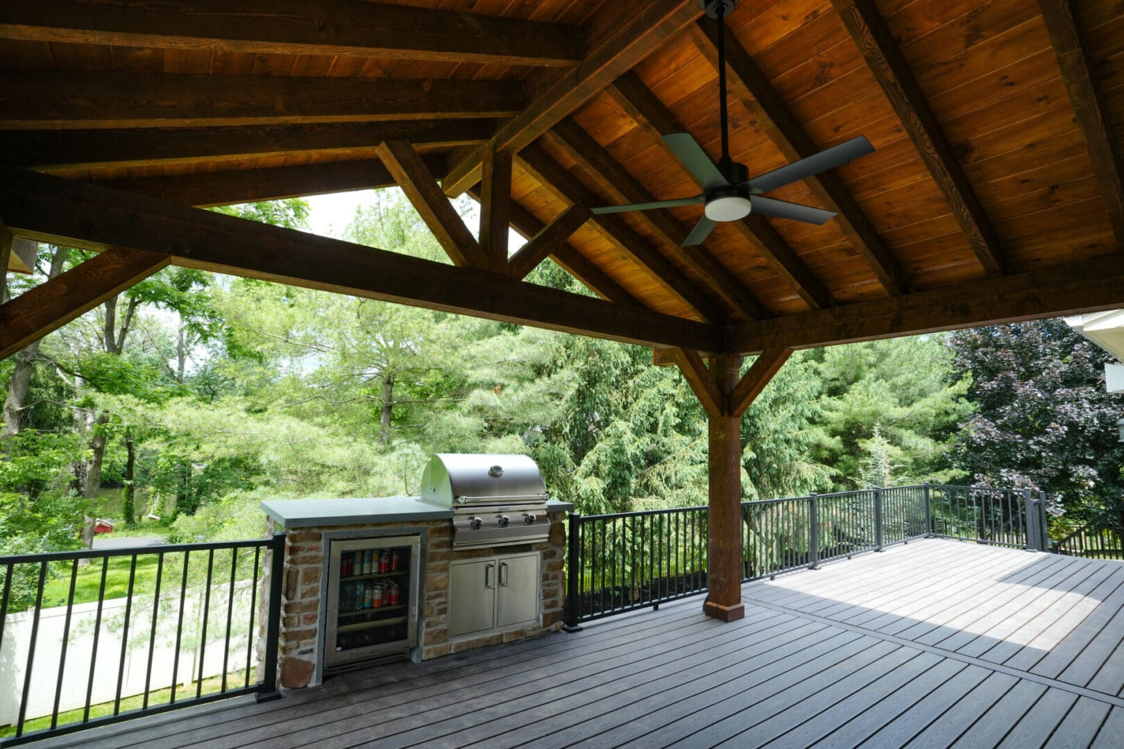 A covered patio with an outdoor grill and fan.