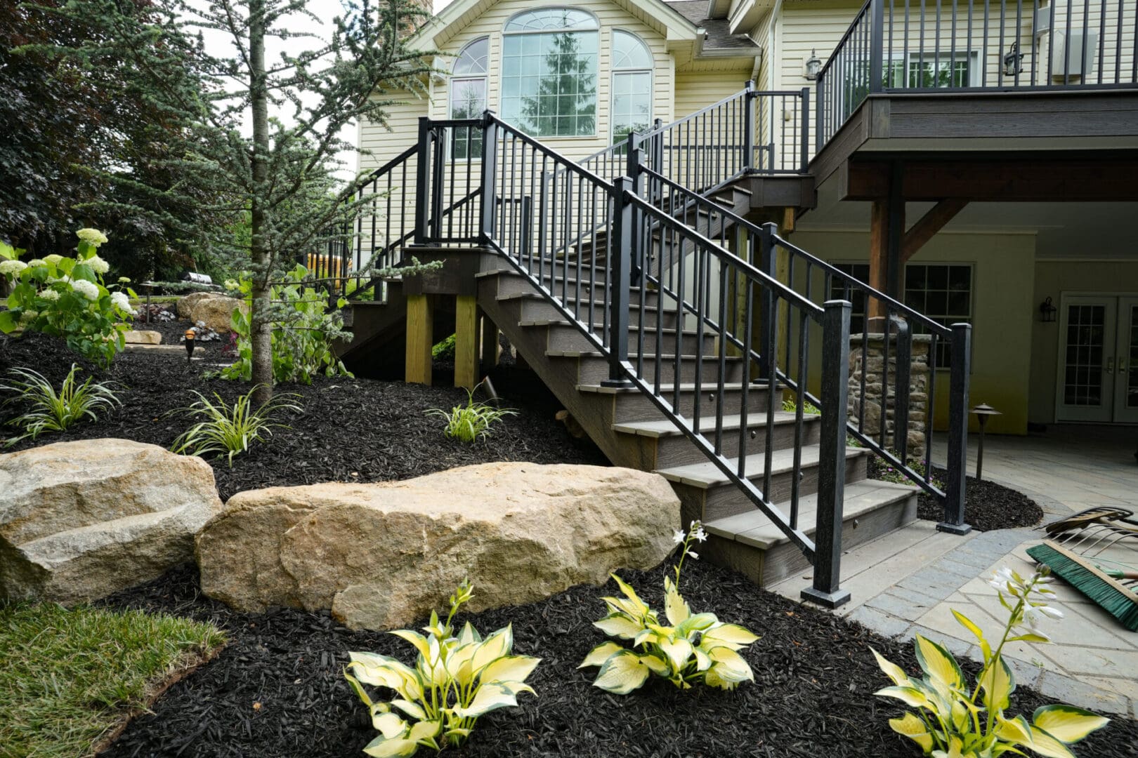 A large rock and some steps in front of a house