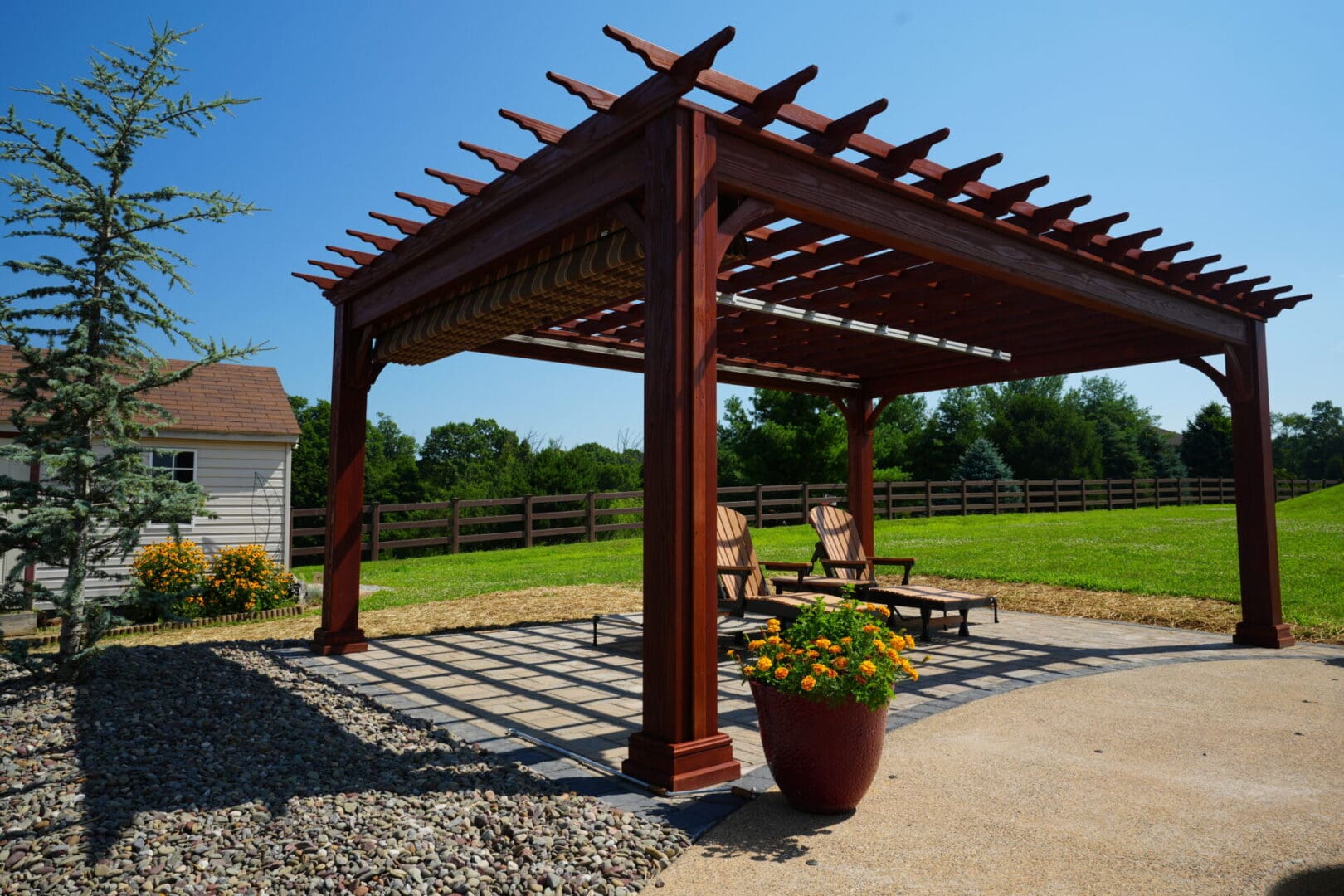 A wooden pergola with a bench and chair in the middle.