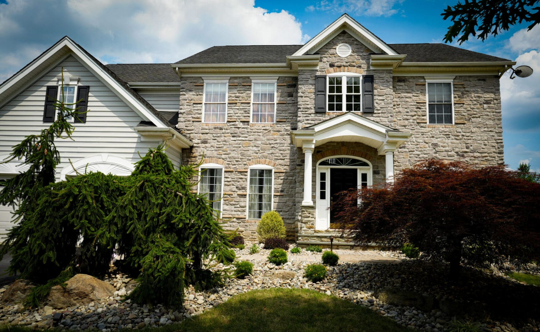 A large brick house with a lot of landscaping around it.