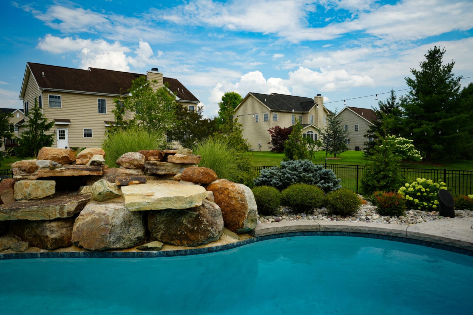 A pool with a waterfall and rocks in the middle of it.