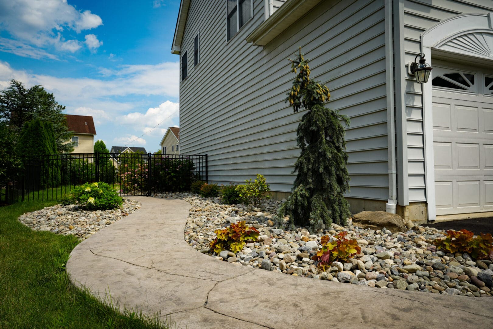 A house with a garden and walkway in the front yard.