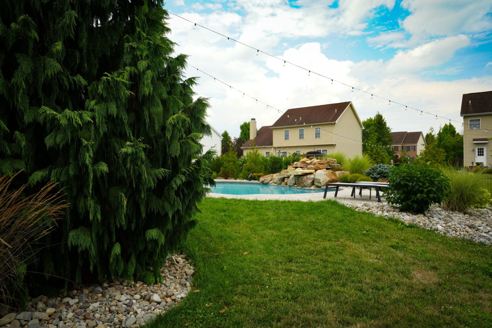 A backyard with pool and lawn area.