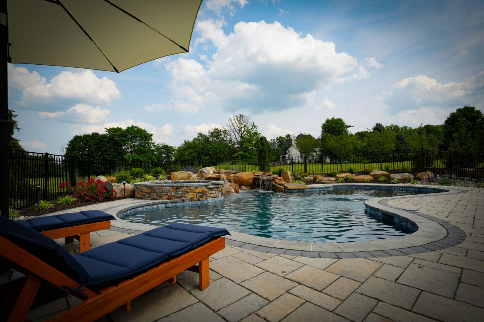 A pool with an umbrella and some chairs