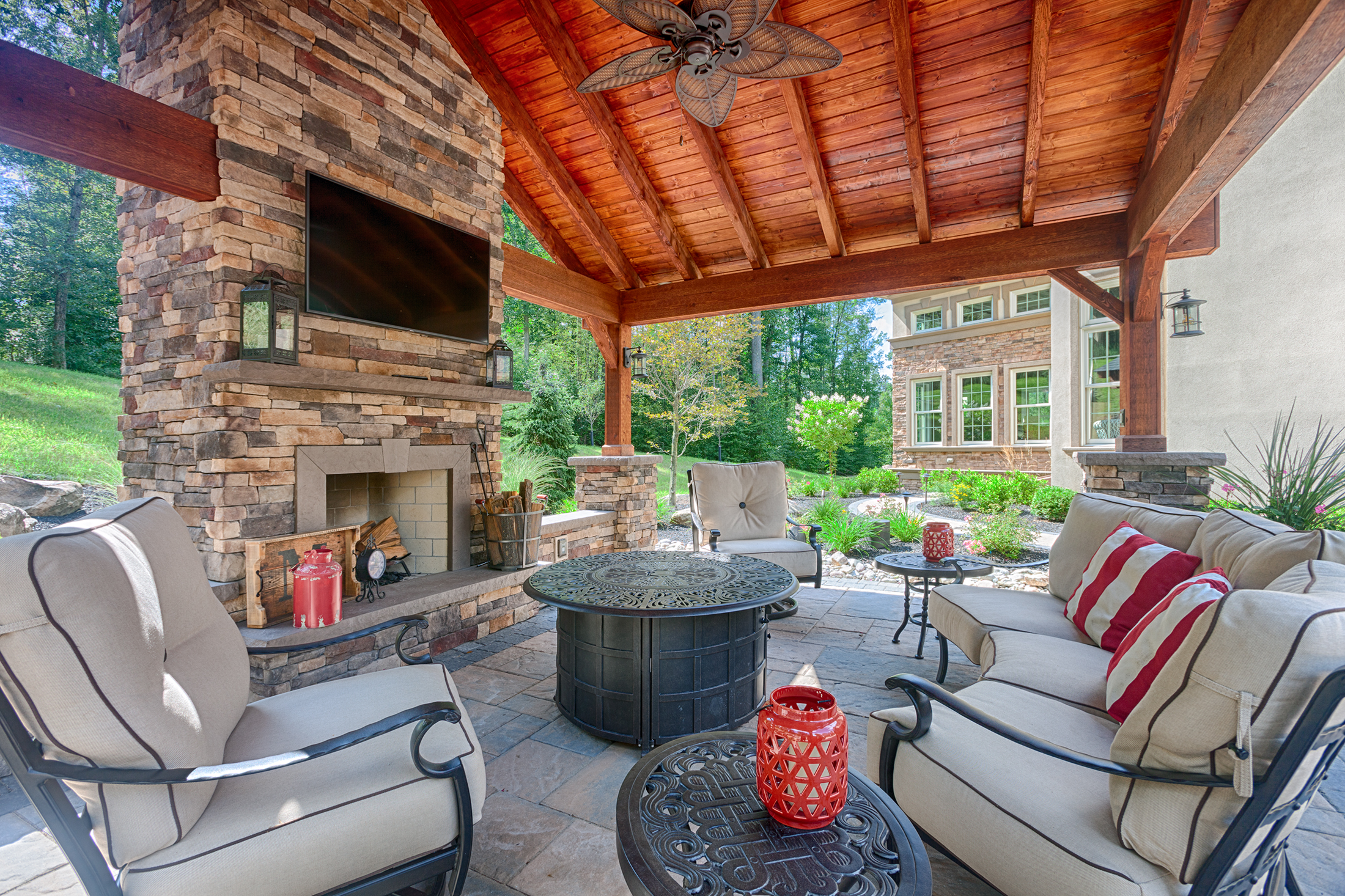 A covered patio with furniture and a fire pit.